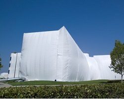 Large building covered in white fumigation tent.