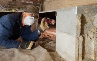 Pest technician inspecting a crawl space in Houston TX home