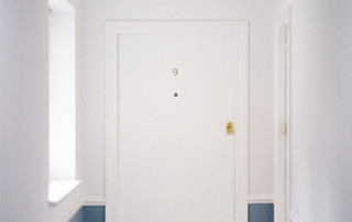 A white apartment door in a hallway labeled nine - Holder's Pest Solutions in Houston TX